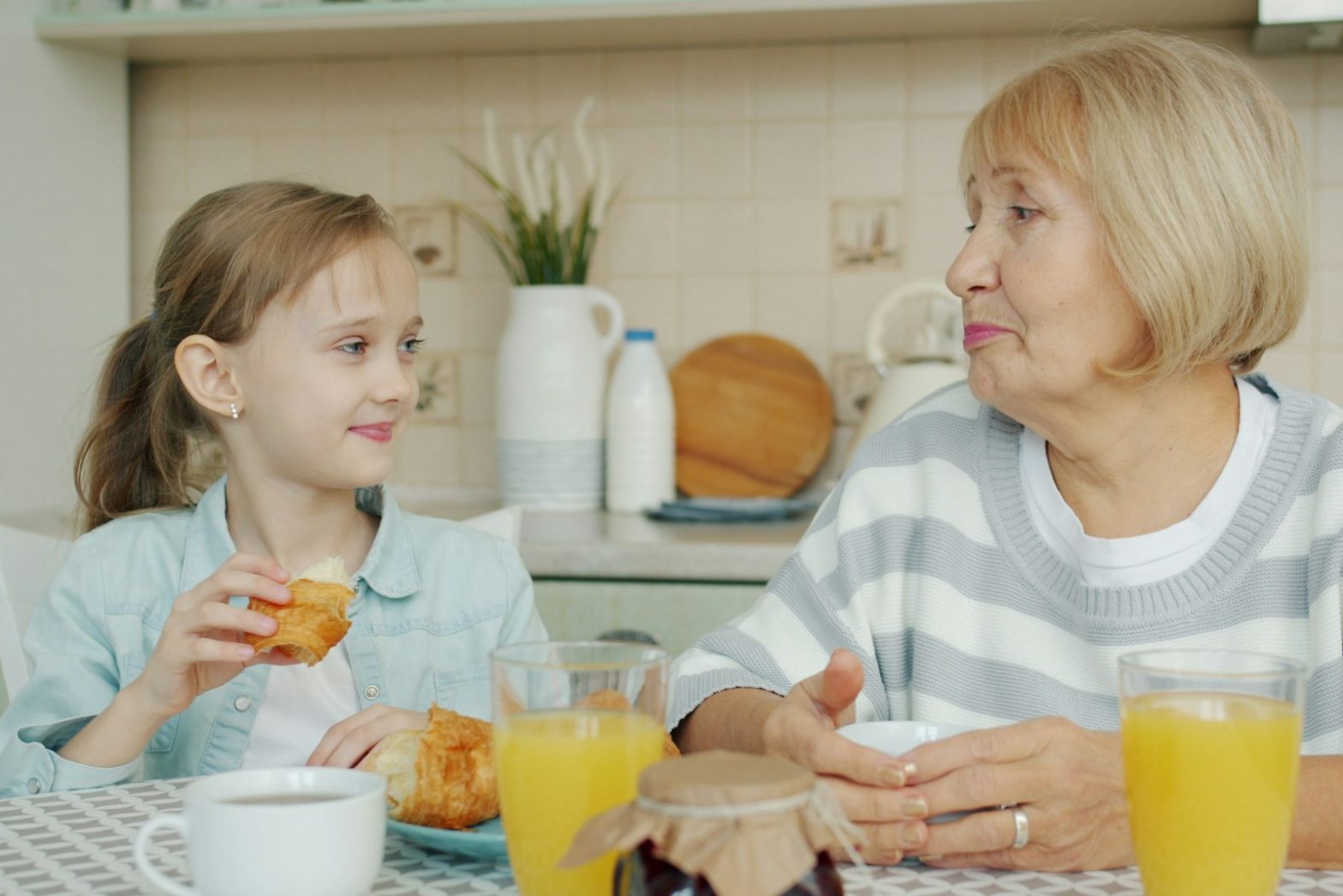 A grandmother and granddaughter talking over breakfast