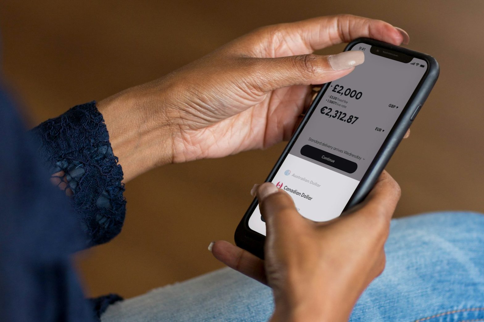 Hands holding a phone showing a banking app