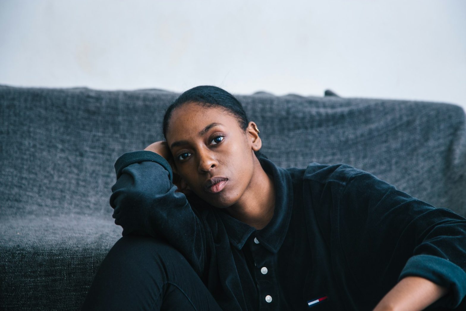 A woman sitting on a sofa looking worried